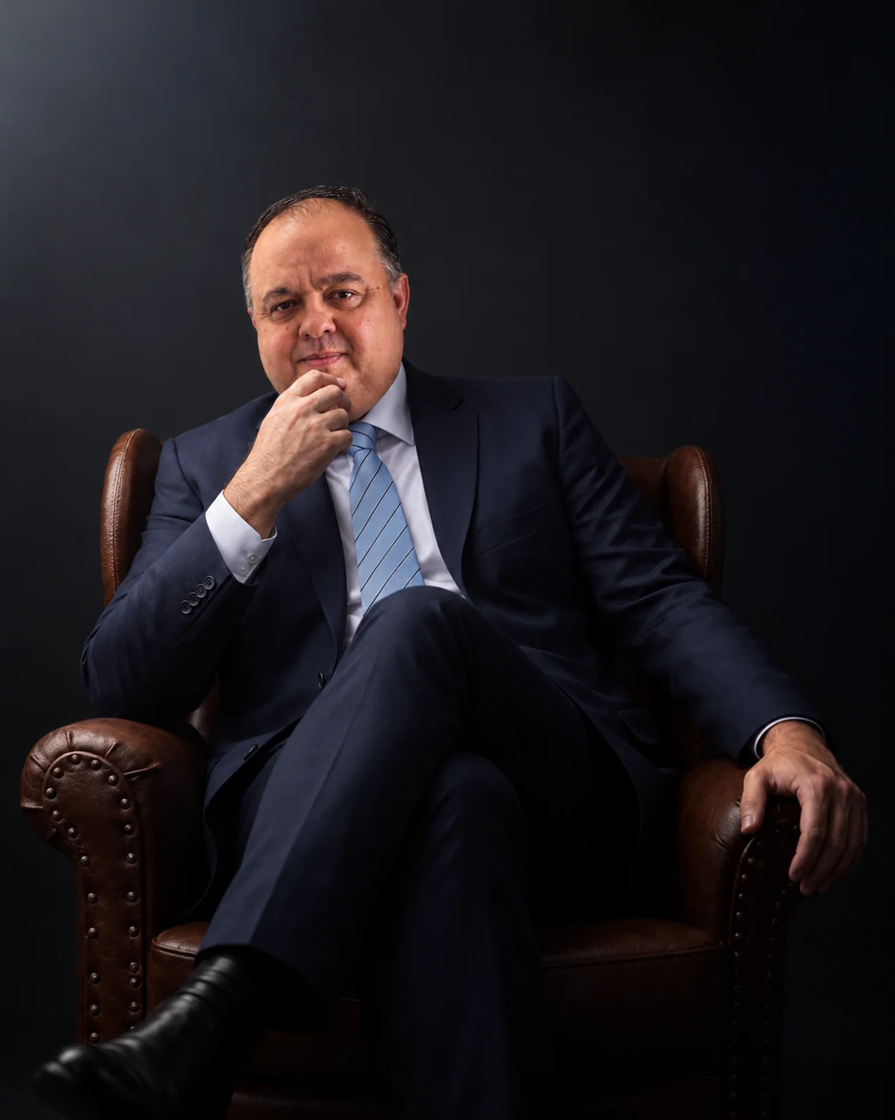 Fabiano Gomes Rasmussen sentado em uma poltrona no retrato institucional