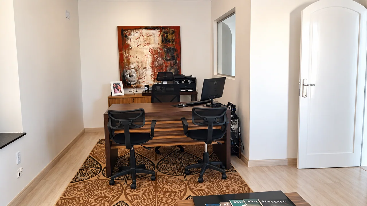 Sala de atendimento do escritório, com mesa de madeira e cadeiras